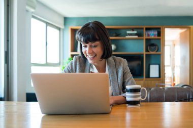 Evden bilgisayarla çalışan bir kadın..