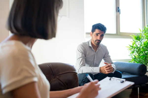 Psycholoog maakt aantekeningen tijdens therapiesessie. — Stockfoto