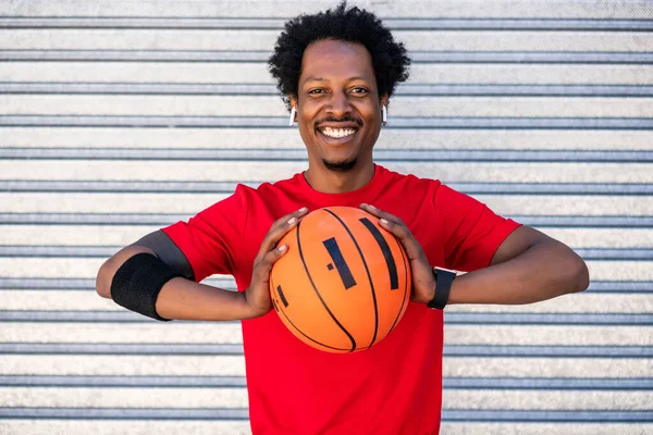 Afro atleta hombre sosteniendo una pelota de baloncesto al aire libre. —  Fotos de Stock