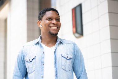 Dışarıda yürürken gülümseyen Afrikalı Amerikalı adam..