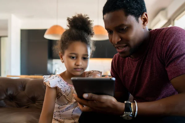 Far och dotter använder digital surfplatta hemma. — Stockfoto