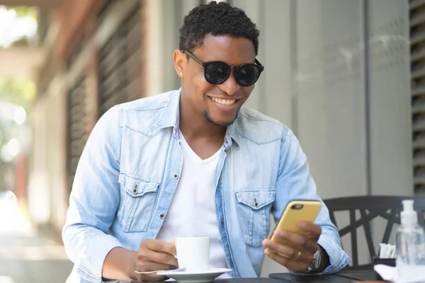 Hombre usando su teléfono móvil en la cafetería. — Foto de Stock