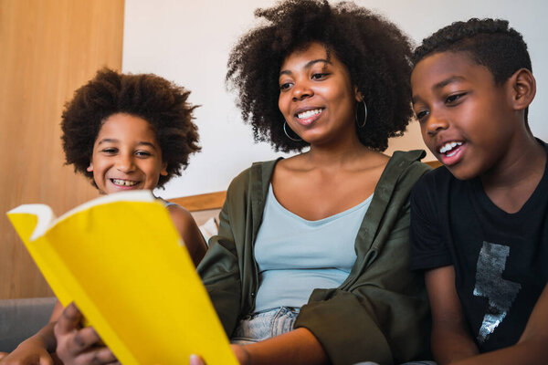 Afro mother reading a book to her children.
