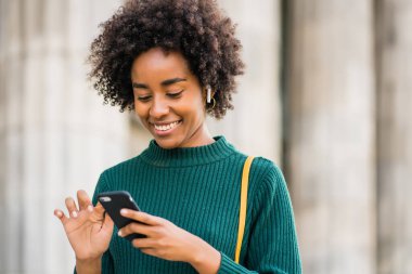 İş kadını cep telefonunu açık havada kullanıyor..