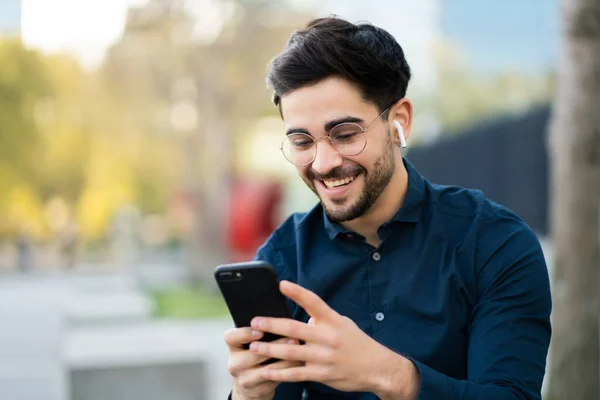 Young man using his mobile phone outdoors.