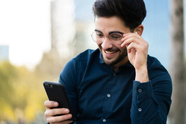 Young man using his mobile phone outdoors.