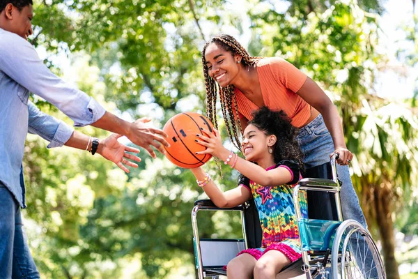 Mädchen im Rollstuhl spielt Basketball mit ihrer Familie. — Stockfoto