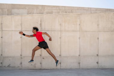 Atletik adam koşuyor ve dışarıda egzersiz yapıyor..