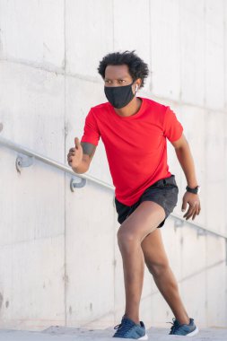 Atletik adam koşuyor ve dışarıda egzersiz yapıyor..