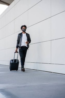 Dışarıda yürürken bavul taşıyan bir turist..