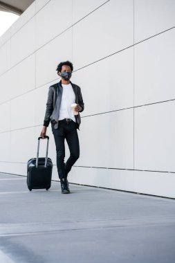 Dışarıda yürürken bavul taşıyan bir turist..