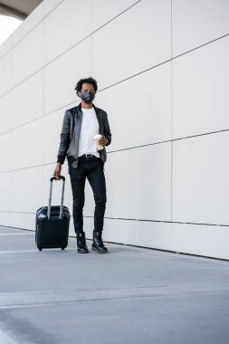 Dışarıda yürürken bavul taşıyan bir turist..