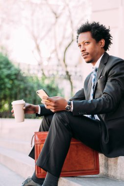 İş adamı cep telefonunu açık havada kullanıyor..