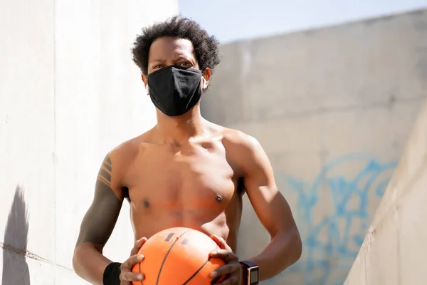 Αφρο αθλητικός άνδρας κρατώντας μπάλα μπάσκετ. — Φωτογραφία Αρχείου
