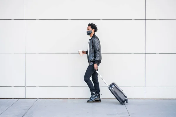 Turista hombre llevando maleta mientras camina al aire libre. — Foto de Stock