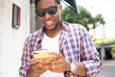 Sokakta cep telefonunu kullanan bir adam..