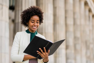 Afro iş kadını elinde bir pano ile sokakta bekliyor..