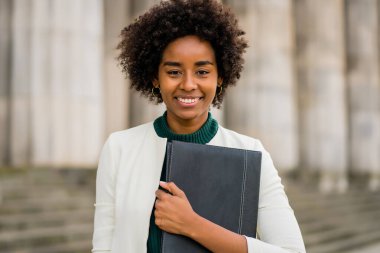 Afro iş kadını elinde bir pano ile sokakta bekliyor..
