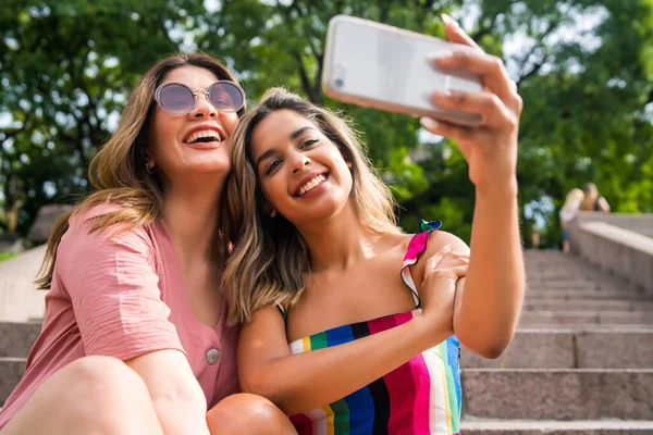 Dois amigos tomando selfie com telefone ao ar livre. — Fotografia de Stock