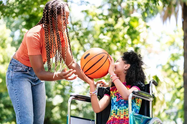 Gadis kecil di kursi roda bermain basket dengan ibunya. — Stok Foto