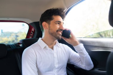 İş adamı arabada telefonla konuşuyor..