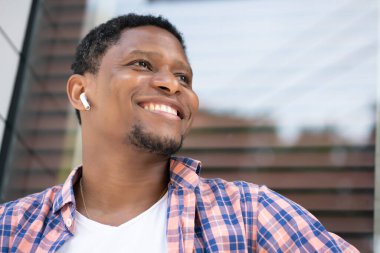 Afro-Amerikalı bir adam mağazanın vitrininde oturuyor..