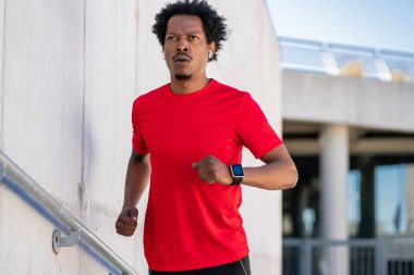 Atletik adam koşuyor ve dışarıda egzersiz yapıyor..