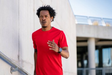 Atletik adam koşuyor ve dışarıda egzersiz yapıyor..