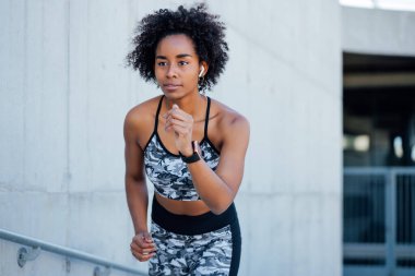 Afro atletik kadın dışarıda koşuyor..