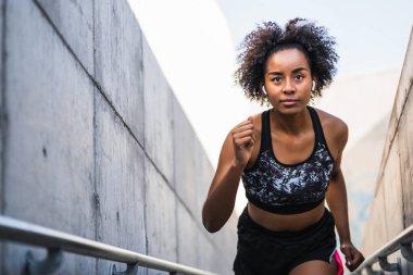 Afro atlet kadın dışarıda koşuyor..