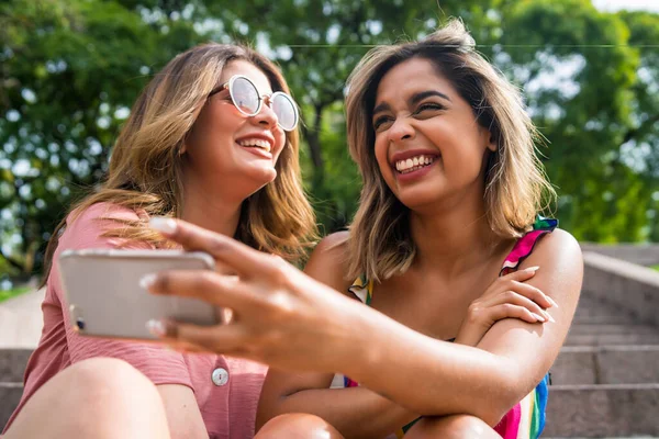 Dois amigos tomando selfie com telefone ao ar livre. — Fotografia de Stock