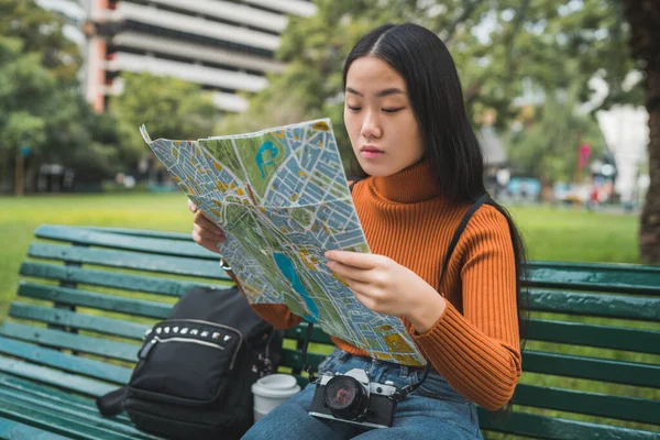 Mulher asiática olhando para um mapa. — Fotografia de Stock