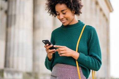 İş kadını cep telefonunu açık havada kullanıyor..