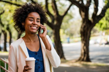 İş kadını dışarıda telefonla konuşuyor..