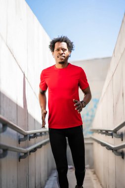 Atletik adam koşuyor ve dışarıda egzersiz yapıyor..