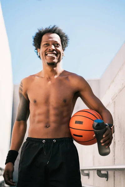 Afro atleta hombre sosteniendo una pelota de baloncesto al aire libre. —  Fotos de Stock