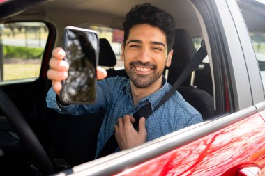 Ekran telefonunda bir şey gösteren adam.