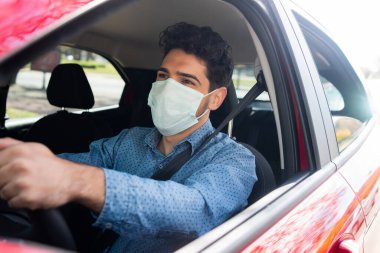 İşe giderken arabasını kullanan bir adam..