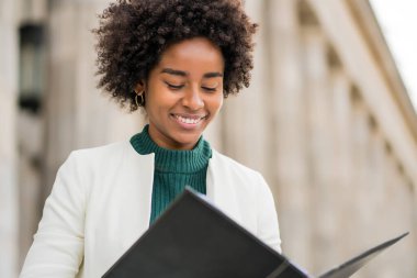 Afro iş kadını elinde bir pano ile sokakta bekliyor..