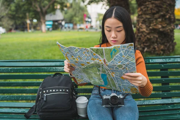 Asian woman looking at a map. — Stock Photo, Image