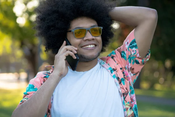 Latin man talking on the phone outdoors.