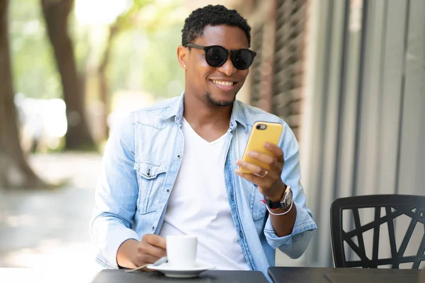 Homme utilisant son téléphone portable au café. — Photo