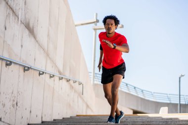 Atletik adam koşuyor ve dışarıda egzersiz yapıyor..