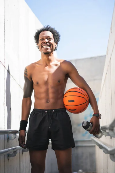 Afro atleta hombre sosteniendo una pelota de baloncesto al aire libre. —  Fotos de Stock