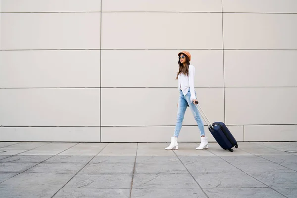 Giovane donna che porta una valigia all'aperto. — Foto Stock