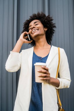 İş kadını dışarıda telefonla konuşuyor..