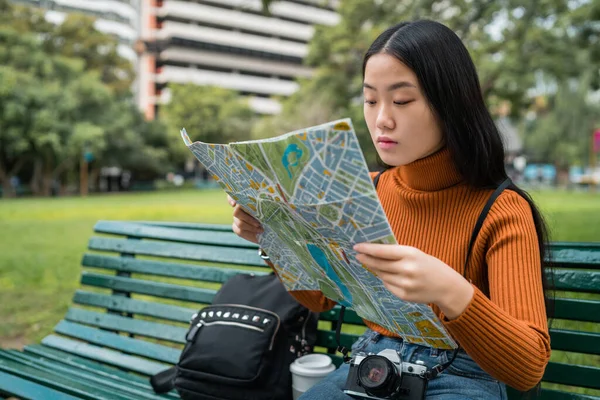 Азиатка смотрит на карту. — стоковое фото
