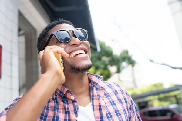 Hombre hablando por teléfono mientras camina por la calle. — Foto de Stock