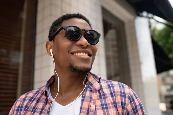 Hombre disfrutando escuchando música con auriculares al aire libre. — Foto de Stock