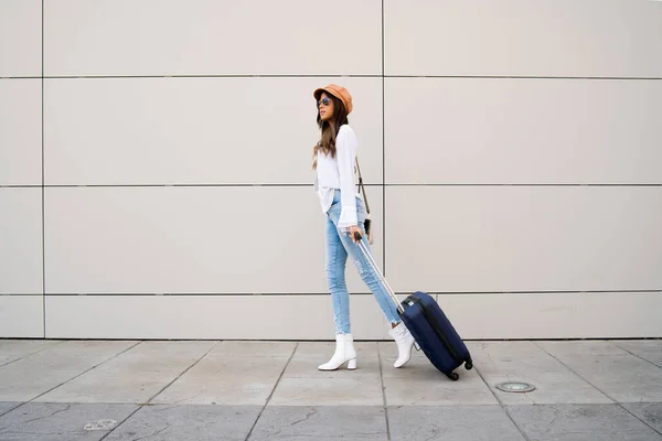 Молода жінка носить валізу на відкритому повітрі . — стокове фото